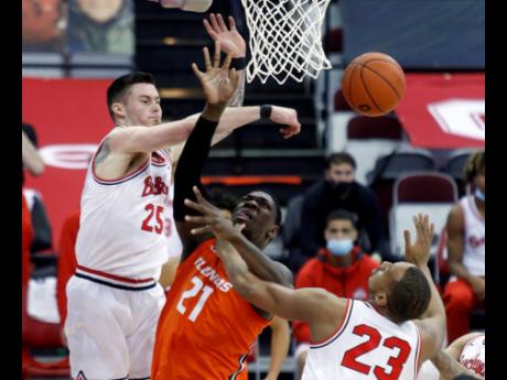Ohio State forward Kyle Young (left) and Illinois centre Kofi Cockburn (centre) come together at the rim as forward Zed Key defends during the first half of an NCAA college basketball game in Columbus, Ohio, on Saturday, March 6.