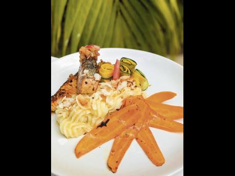 Herb-grilled salmon with roasted pineapple salsa, served with coconut mash and seasonal vegetables.