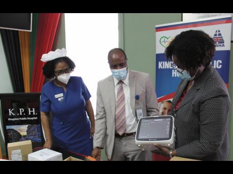 Government of Jamaica officials, including CEO of the Kingston Public Hospital, Bruknell Stewart (centre), view a sample medical equipment last Monday, following a donation from the Embassy of Japan. The gift of medical supplies and equipment include bedsi