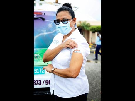 Dr Jacquiline Bisasor-McKenzie, chief medical officer, proudly displays her vaccination Band-Aid on Wednesday. She got the jab at the Spanish Town Hospital. 