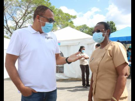Minister of Health and Wellness Dr Christopher Tufton (left) speaks with Audrey Samuels Gilling, senior public health nurse in the St James Public Health Services, during the minister’s tour of western Jamaica following Wednesday’s start of the governm