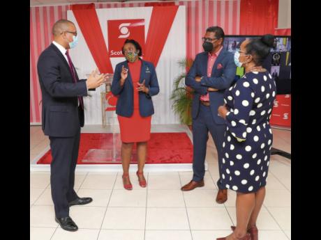 Scotiabank’s Perrin Gayle (left), senior vice-president, retail banking, and Yvett Anderson, district vice-president, are snapped in conversation with Sheryl Anderson (second left), chief executive officer of QSSI Ltd, a former participant in the Scotiab