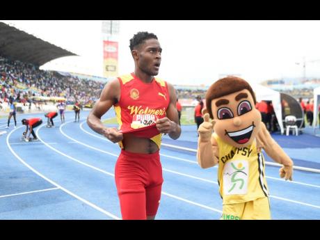 ISSA/GraceKennedy Boys and Girls’ Athletics Championships official mascot, ‘Champsy’, runs alongside Wolmer’s Boys’ Jeremy Farr, who was victorious in the Class One Boys’ 400m event at the National Stadium on Saturday, March 30, 2019.