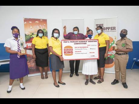 Duhaney Park Primary School Principal Coleen Reid Grant (centre) with coaches Cadena Josephs (second left) and Denise Howell Douglas (second right). A third coach, Mary Gordon, and Amoya Edwards (third right), a member of the team, hold the symbolic cheque