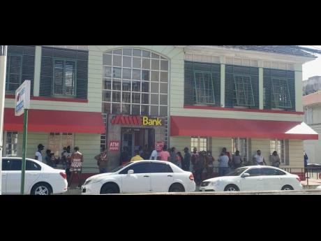 
Customers queue outside a branch of a financial institution in Montego Bay, St James, ignoring physical-distancing protocols as they wait to conduct business inside. Public health inspector Lennox Wallace is urging businesses to do more to ensure that pro
