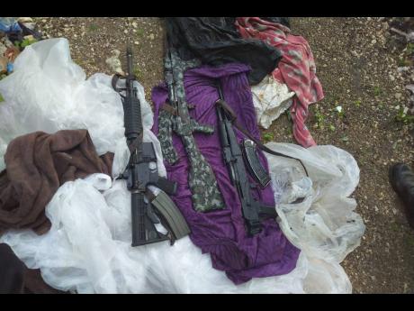 The three high-powered weapons seized by a police-military team during an operation in Norwood, St James, yesterday.