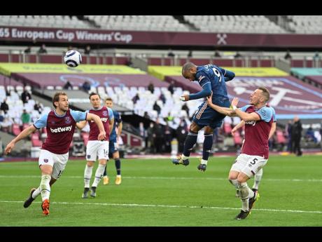 Arsenal's Alexandre Lacazette (second right) scores his side's third goal during their English Premier League match against West Ham United at the London Stadium in London, England, yesterday.