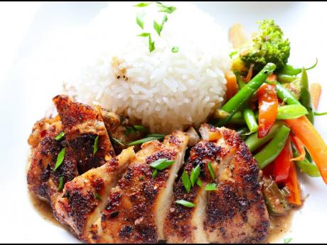 1. Pan-seared chicken topped with garlic-butter sauce is served with sautéed vegetables and jasmine rice.