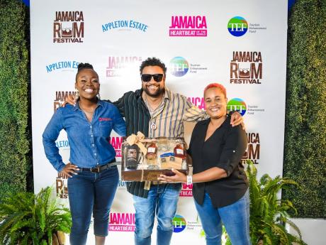 Reshima Kelly-Williams, brand marketing manager for Digicel Jamaica, stands with reggae and dancehall star Shaggy while he is being presented with a gift from Leleika-Dee Barnes, channel and customer marketing director, J. Wray and Nephew Limited.