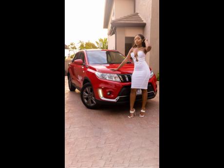 The birthday babe was not short on outfits, and this white number and its plunging bodice stands out perfectly against the red of the SUV.