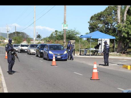 
Police personnel man a checkpoint in Lionel Town, Clarendon, on Saturday. A 48-hour curfew imposed on the community last Friday lapsed Sunday evening.