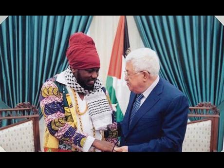 Blakk Rasta shakes hands with President Mahmoud Abbas during a visit to Palestine, where he was invited to meet with the leader to help spread the message of peace in the region.