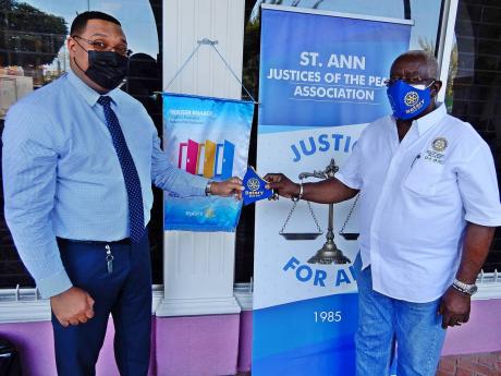 Rotary Club of Ocho Rios’ newest member, Paolo Fakhourie (left), collects a mask from Pixley Irons, JP and president of the Rotary Club, at the start of the mask distribution initiative in Ocho Rios. 