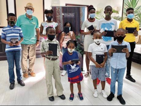 Pierre Battaglia, general manager of Couples Sans Souci, with some of the children of staff who received tablets during a presentation at the hotel recently.  