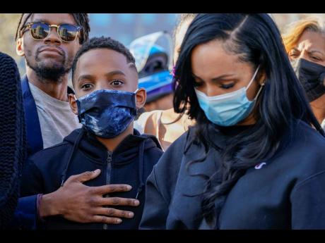One of DMX’s sons (centre) is joined by friends and family members during a prayer vigil for the rapper outside of White Plains Hospital on Monday.