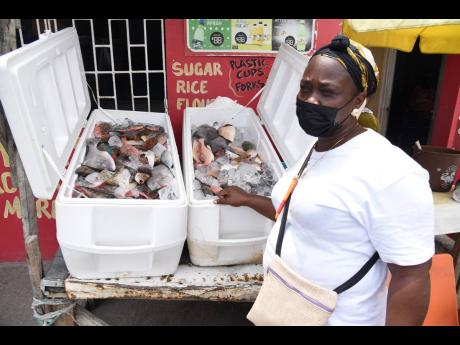 Maureen ‘Angella’ McDermott, a vendor who operates at the Rae Town fishing village in Kingston, shows a fresh supply of fish she has for sale. She lamented having lost thousands of dollars from rotting fish on the Easter lockdown weekend. 