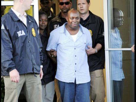 Christopher 'Dudus' Coke is led away by law-enforcement officials at Westchester County Airport in New York in 2010.
