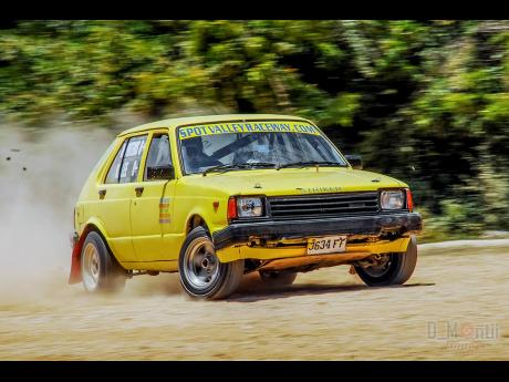 Marvin Porteous takes the Toyota Starlet through the loose-gravel course, at a sprint event at Spot Valley, 
St James.