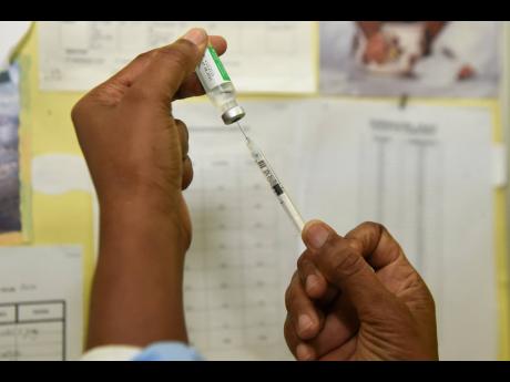 
Public health nurse Lorraine Holt prepares a COVID-19 vaccine for a healthcare worker at the Windward Road Health Centre in Kingston on Monday, March 15. 