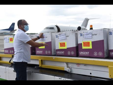Minister of Health and Wellness Dr Christopher Tufton accepting a shipment of 75,000 doses of AstraZeneca COVID-19 vaccines shortly after it arrived at the Norman Manley International Airport in Kingston via a chartered flight from Ghana on Thursday, April