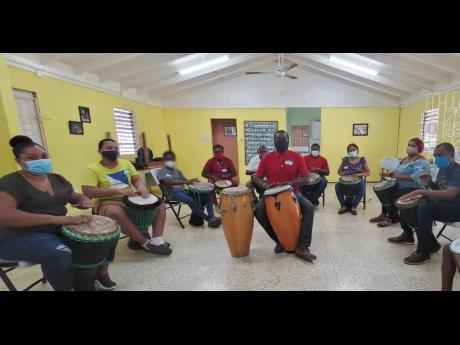 Jesse Golding (centre) of the Edna Manley College of the Visual and Performing Arts in a training session with caregivers at the western and northeast regions at the SOS Children’s Village in Barrett Town, St James.