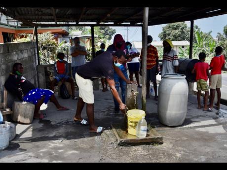 People collect water not contaminated by volcanic ash after the eruption of La Soufriere volcano in Wallilabou, on the western side of the Caribbean island of St Vincent, Monday, April 12, 2021.