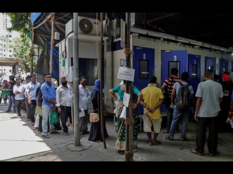 People line up for COVID-19 test in Mumbai, India, yesterday. The country of almost 1.4 billion people is seeing a crippling surge of infections that is threatening to overwhelm hospitals in hard-hit cities.