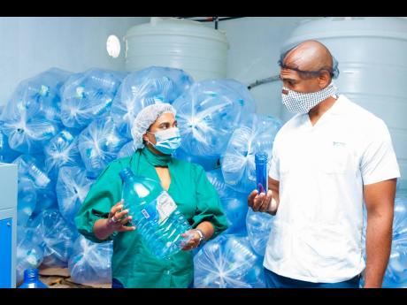 Dr Alfred Dawes observes the recycling and packaging capabilities at Lifespan Spring Water Ltd’s Buff Bay Portland facility along with Company CEO Nayana Williams.