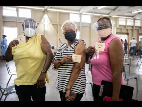 (From left) Delroy Pottinger, Roma Binns and Andrea Francis moments after receiving their dose of the Oxford-AstraZeneca COVID-19 vaccine at the Mona Ageing and Wellness Centre on Sunday. 