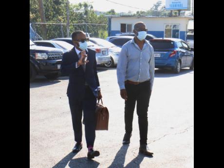Able Don-Foote (left), attorney-at-law, reports to the  Montego Bay Police Station with his client, George Wright, member of parliament for Westmoreland Central, in relation to the alleged beating of a woman. An altercation captured on CCTV later became a 