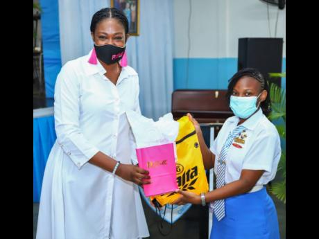 Dejanae Green (right), president of the student council, Grade 12, receives gifts from Michelle-Ann Letman. The gifts included personalised items for each girl from Letman and a Malta goody bag from the D&G Foundation.