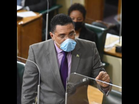 A masked Prime Minister Andrew Holness speaking in Parliament on Tuesday, March 30.