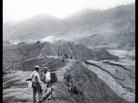 In this 1902 photo provided by York Museums Trust, men survey the devastation of the landscape following eruptions of La Soufrière, a volcano on the island of St Vincent.