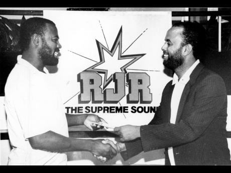  Roxcosmo Thomas (left), emerged as the winner in the ‘Sharp Talk Election Quiz’, which was conducted on Radio Jamaica (RJR). Here, Roxcosmo accepts his cheque for $5,000 from Michael Sharpe, host of ‘Sharp Talk’, for correctly predicting which par
