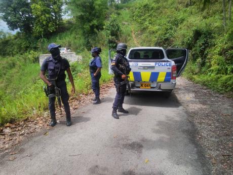 Police officers attached to the St Elizabeth Police Division combing a section of Bronte Common community for illegal weapons, at the location where three alleged gunmen were shot and killed Thursday evening after they challenged the police in a shoot-out.