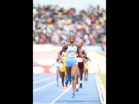 
Rushana Dwyer of Edwin Allen is all smiles as she prepares to cross the finish line on her way to winning the Class Two girls 800m finals at the ISSA/GraceKennedy Boys and Girls’ Athletics Championships at the National Stadium on Saturday, March 30, 201
