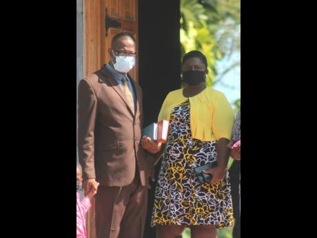 George Wright, MP for Westmoreland Central, and an unidentified woman depart St Peter's Anglican Church in Petersfield, Westmoreland, on Sunday morning. The parliamentarian has been embroiled in an assault saga over the last two weeks.
