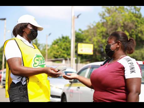 One of SVL’s Supa Sellaz subagents, Nicky Watson (left), makes a sale to passer-by Denise Davis.
