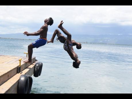 Thadius Brown (right), 19, Ronaldinho Brown (centre), 19, and 18-year-old Prince Bryan dive off the Port Royal Pier on Saturday. 
