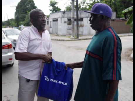 Carlton Byfield (left) presents Patrick Cunningham with a gift bag, courtesy of Tank-Weld Metals Ltd, on Sunday.