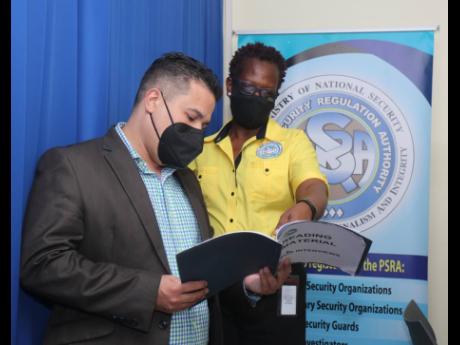 Senator Matthew Samuda, minister without portfolio in the Ministry of National Security, and Vivette Webber McLaughlin, operations manager of the western regional branch of the Private Security Regulations Authority in Montego Bay, St James, look through a