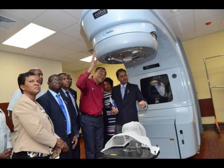 
Health and Wellness Minister Dr Christopher Tufton (second right) and other officials examine the LINAC machine at the opening of National Cancer Treatment Centre at St Joseph’s Hospital on Monday, November 26, 2018.