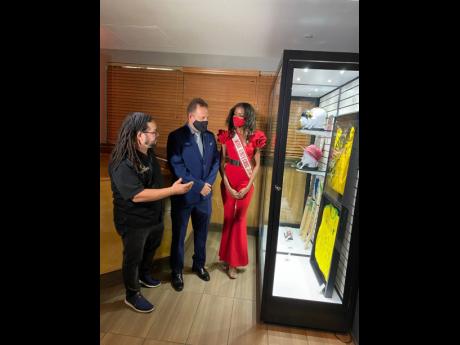 Island Space Caribbean Museum owner David Muir (left) and Jamaica's Consul General to Miami Oliver Mair give Miqueal-Symone Williams a tour. 