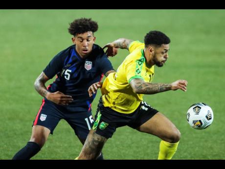 
USA’s Chris Richard, (left) duels for the ball with Jamaica’s Andre Gray during the international friendly match between USA and Jamaica at SC Wiener Neustadt stadium in Wiener Neustadt, Austria, Thursday, March 25, 2021. 
