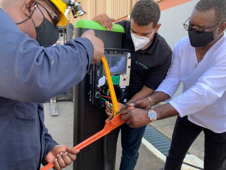 Wayne McKenzie, InterEnergy Country Manager, Jamaica, collaborates with Harold Frias, SCADA Engineer, InterEnergy Systems and Michael Hunt, Instrumentation & Electrical Technician, InterEnergy, to connect electrical wiring during a demo installation of an 
