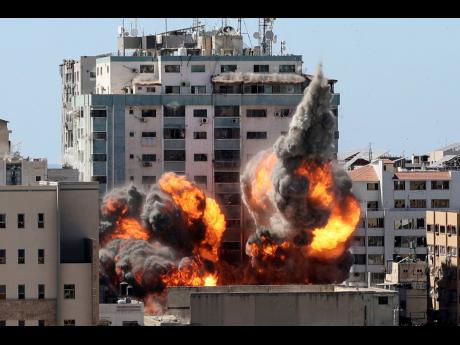 
A ball of fire erupts from a building housing various international media, including The Associated Press, after an Israeli airstrike yesterday in Gaza City. 
