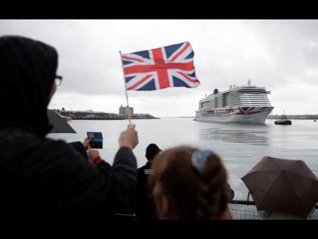 A person waves a Union Jack flag as the new P&O cruise ship ‘Iona’ arrives in Southampton, England, for the first time ahead of its naming ceremony on Sunday.