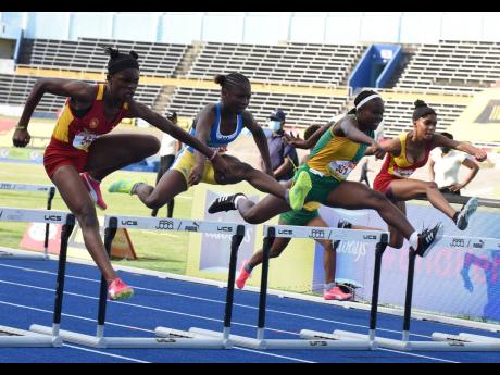 From left: Wolmer’s Girls’ School’s Tiana Marshall clears the final hurdle in the Class Four girls’ 70m hurdles final ahead of Hydel High School’s Tihanna Reid, Vere Technical High School’s Kecia King, and Wolmer’s Natrilia Campbell at the IS