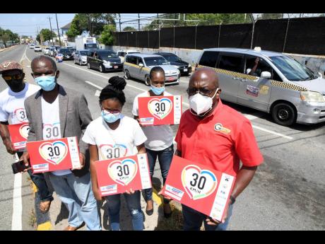 Egeton Newman (second left), president of the Transport Operators Development Sustainable Services, and Alphonos Grennell (right), managing director of Grennell’s Driving School, and other members lobby for taxi drivers for a 30km/h speed limit in built-