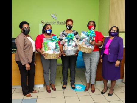 Yvette Morris (left), assistant branch manager, Sagicor Bank May Pen, and Natalie Powell (right), branch manager, Sagicor Bank May Pen, are pictured with (from second left) Francine Swaby, York Town Primary School principal, and teachers Nadine McKenzie an